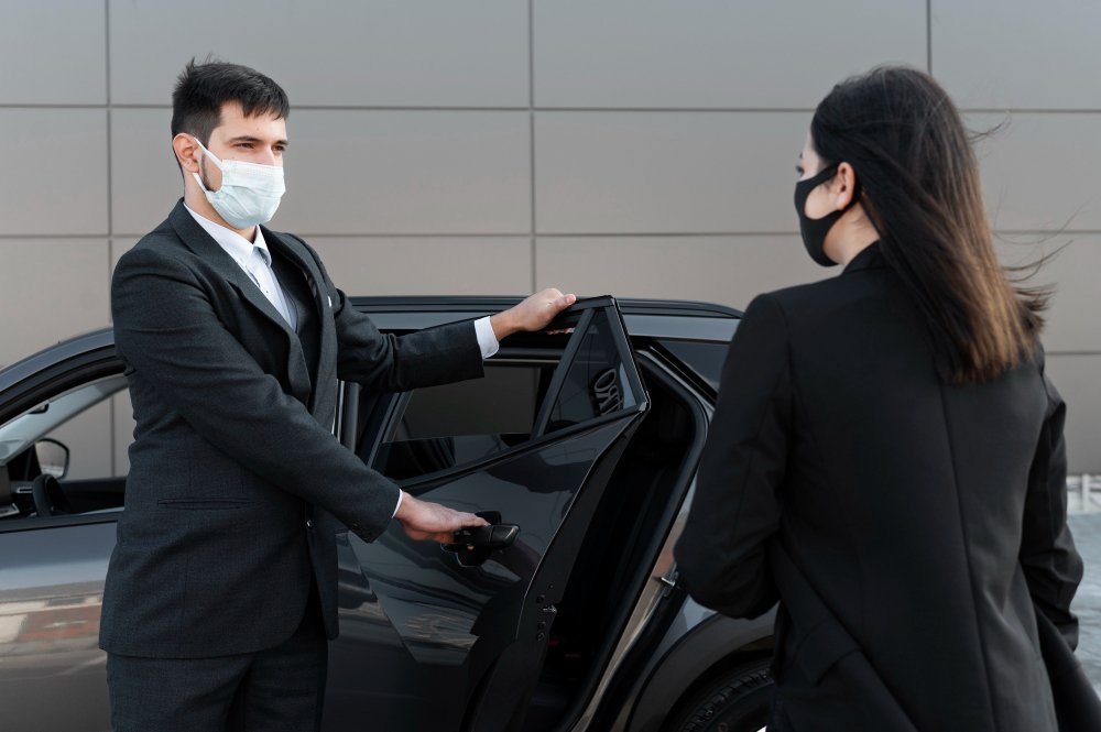 A man and woman in business suits are entering a car, suggesting a professional setting in Dubai.