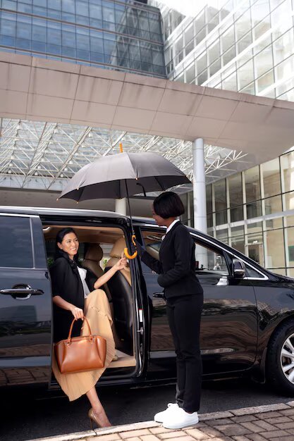 A well-dressed couple walks under an umbrella on a rainy Dubai street, with a chauffeur by a luxury car. The skyline glows, reflecting on wet pavement.