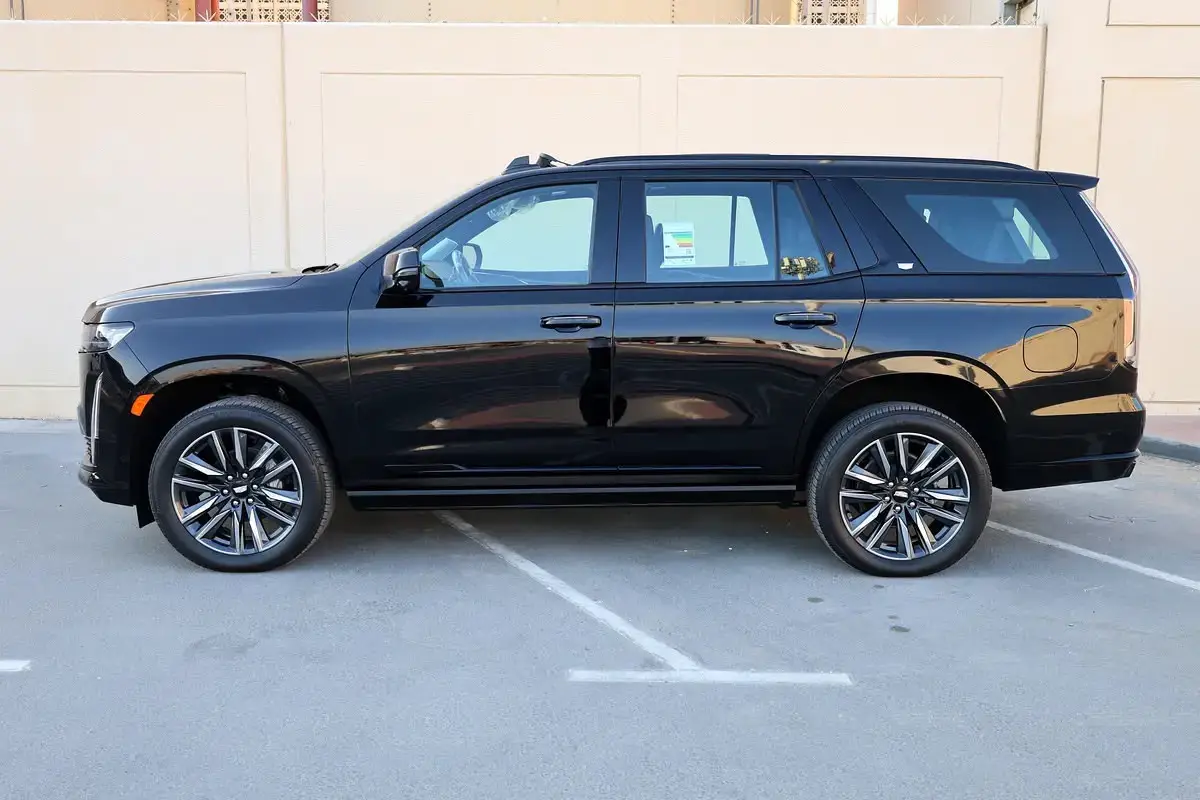 The vehicle appears to be a black Cadillac Escalade, featuring a full-size luxury SUV body style and multi-spoke alloy wheels.